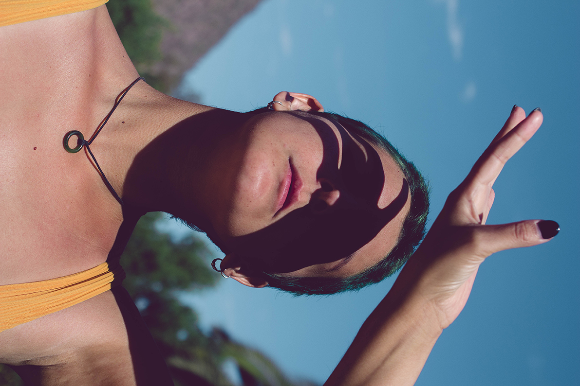 Imagen de una mujer mirando el sol y cubriéndose los ojos